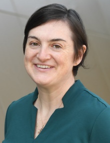 woman outside, smiling.