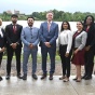 Group of people posing for a photo outside. 