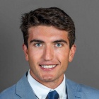 man wearing suit and tie, smiling. 