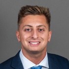 man wearing suit and tie, smiling. 