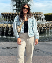 woman standing outside during the day, in front of a decorative fountain.