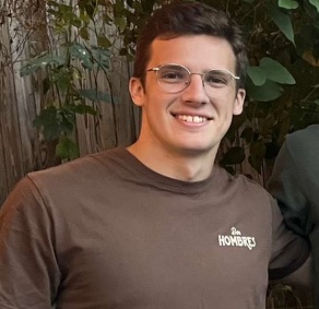 man smiling wearing brown tshirt. 