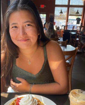 Young woman in a restaurant, smiling.