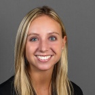 woman smiling, wearing black jacket. 