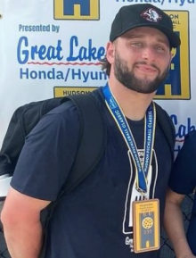 man standing outside at a sports event. 