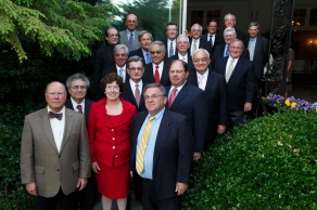 group of alumni posing together outside in a garden. 