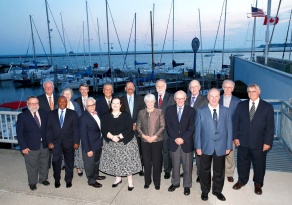 Group of people outside posing for a photo in a marina at sunset. 