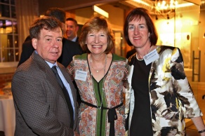 Group of three people attending a social event, smiling. 