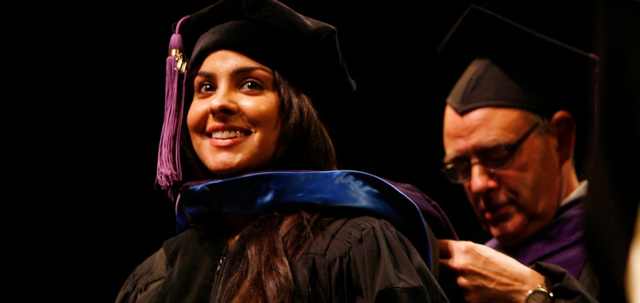 photo of graduate getting hooded during their commencement ceremony.
