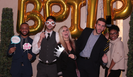 students posing with props, smiling, balloons that spell BPILP behind them. 