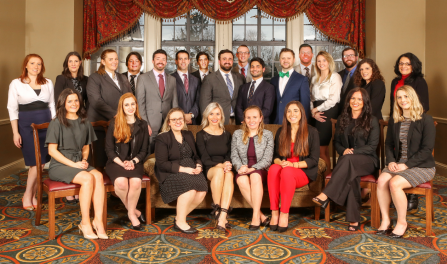 group of people in a fancy room, posed together for a group photo. 