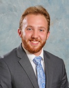 A man wearing business suit, smiling. 