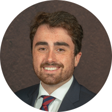 young man wearing a suit and tie, smiling.