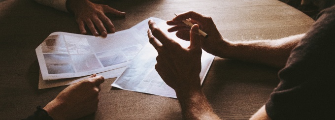 group of people sitting near round brown wooden table.
