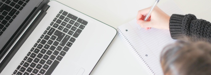 Photo of man writing a letter with a pen.