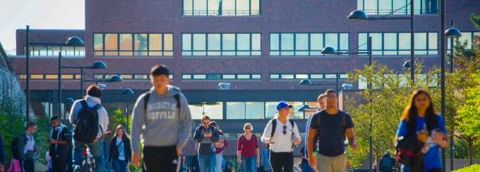 Students walking on the main walkway at the University at Buffalo North Campus with the Capen building in the background.