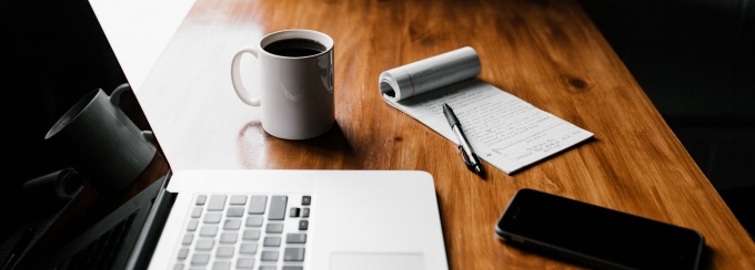 Photo of hands writing in a daily planner.