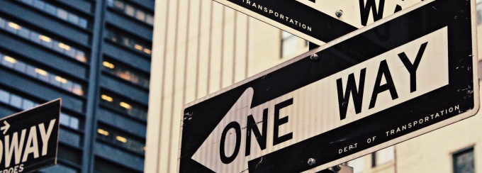 photo of two one-way signs pointing in opposite directions.