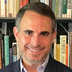 Man standing in front of a bookcase. 