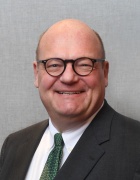 man wearing glasses and smiling.