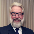 Man with beard, glasses, smiling. 