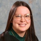 Woman wearing black, smiling.