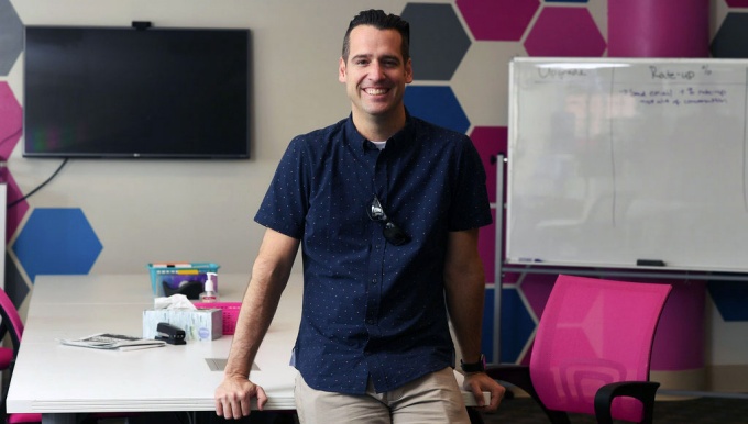 Adrian Dayton leaning against a table.