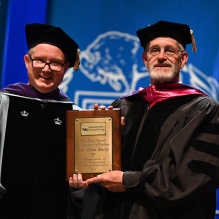 two men holding up a plaque. 