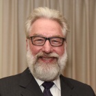 man with beard, glasses, smiling. 
