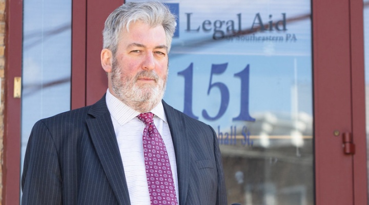 man standing outside a Legal Aid building. 