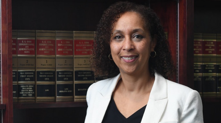woman standing in front of legal books. 