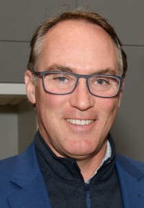 Man wearing glasses, smiling. 