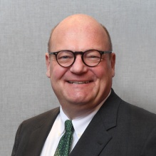 Man wearing glasses, smiling.