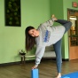 Woman in a yoga pose in a green room. 