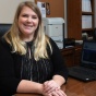 law student sitting at a desk, smiling. 