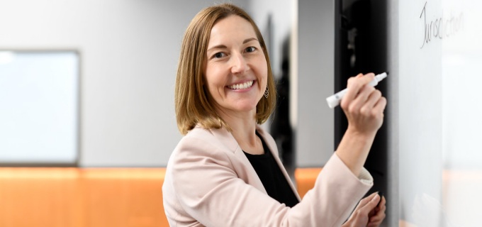 Abraham writing on a white board in a classroom.