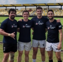 rugby players in a sports arena posing for a photo.