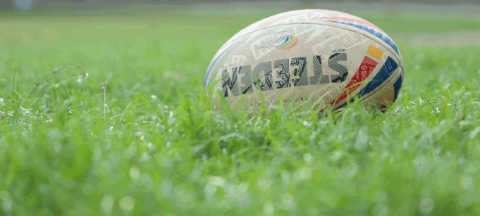 photo of a rugby football sitting in a field.