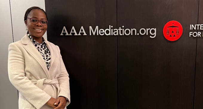 student standing next to a AAA Mediation.org sign.