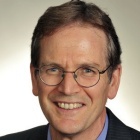 man wearing glasses, smiling.