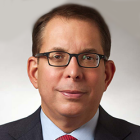 man wearing business suit and wearing glasses.