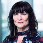 woman wearing flowery dress, smiling.