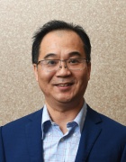 man wearing glasses, smiling.