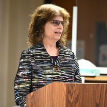 woman speaking at a podium.