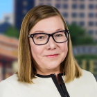 woman wearing glasses, smiling.