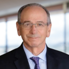 man wearning glasses, business suit, smiling.