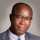 man wearing glasses, smiling.