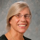 woman wearing black top, smiling.