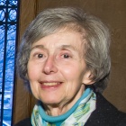 woman wearing blue scarf, smiling.