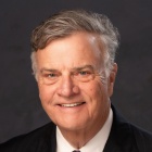 man wearing tie, smiling.